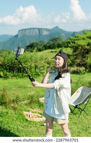 Woman taking a selfie at a campsite