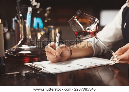 Faceless person hands hold stem glass with red wine. Royalty-Free Stock Photo #2287985345