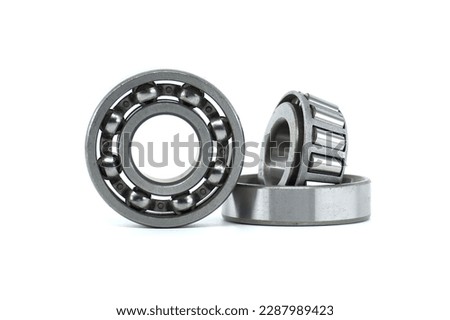 Ball bearings and tapered roller bearing isolated on white background. Spare parts for machinery and automotive industry Royalty-Free Stock Photo #2287989423