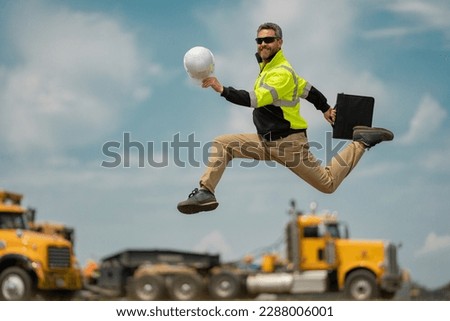 Construction worker excited jump on construction site. Construction engineer worker in builder uniform on construction. Portrait of builder ready to build new house. Royalty-Free Stock Photo #2288006001