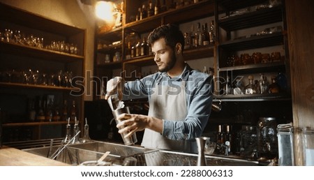 Authentic professional caucasian bartender flaring his shaker before making a cocktail. Experienced barman juggling with his equipment - food and drink Royalty-Free Stock Photo #2288006313
