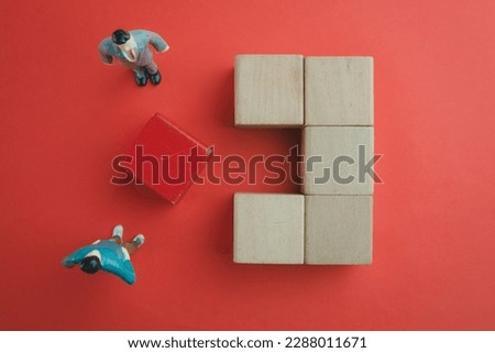 A Business team focus on blank red wooden cube among blank wooden cube over red background.