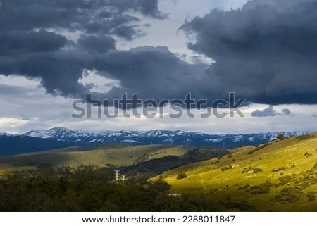 Green rolling hills under cloudy sky.