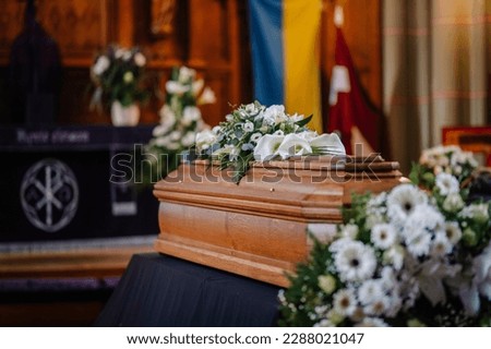 A coffin decorated with many flowers and candles in a beautiful church, ceremony Royalty-Free Stock Photo #2288021047