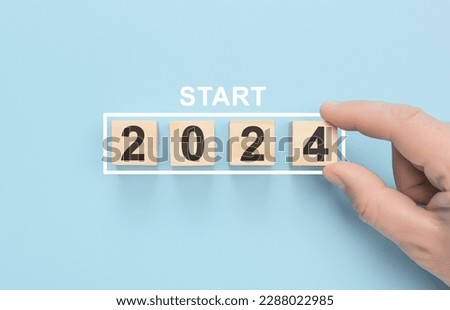 Man hand flipping cubes with year 2023 to 2024. new year concept. copy space. Hand holding wooden cube with flip over block 2023 to 2024 word on table background