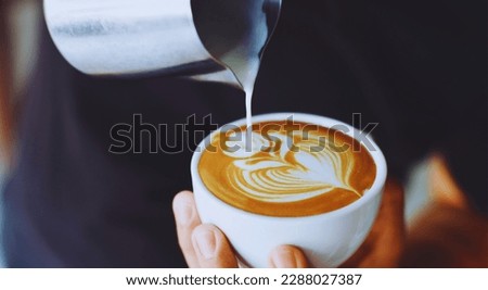 a man person making latte art in a cup of coffee. Royalty-Free Stock Photo #2288027387