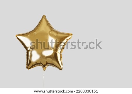 Golden balloon on light grey background Royalty-Free Stock Photo #2288030151