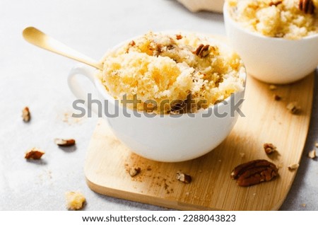 Banana Mug Cake, Homemade Cake Cooked in the Microwave and decorated with Pecans Royalty-Free Stock Photo #2288043823