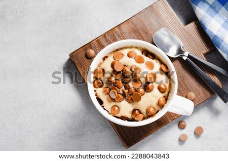 Peanut Butter and Chocolate Chips Mug Cake, Homemade Cake Cooked in the Microwave on Bright Background Royalty-Free Stock Photo #2288043843