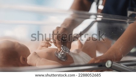 Close Up Portrait of a Happy African Female Pediatrician Uses Stethoscope to Listen to Heartbeat and Lungs of Recovering Newborn Baby Resting in Bassinet. Young Doctor Does Checkup in Nursery Royalty-Free Stock Photo #2288052685