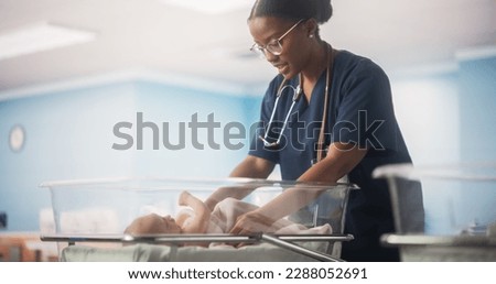 Portrait of a Young Doctor Checking Up and Caring for a Newborn Baby Lying in a Bassinet in a Modern Maternity Ward. Cute Neonate Healthy Child Waiting for Mother to Take the Baby Home Royalty-Free Stock Photo #2288052691