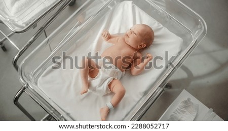Adorable Caucasian Newborn Child Lying in Hospital Bed in a Nursery Clinic. Little Playful and Healthy Baby. Medical Health Care, Maternity and Parenthood Concept Royalty-Free Stock Photo #2288052717