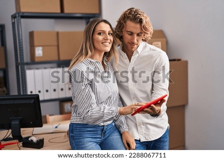 Man and woman ecommerce business workers using touchpad at office