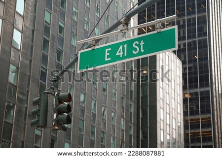 Green big East 41st Street sign hanging on a arch pole in the streets of midtown Manhattan in New York City