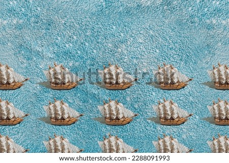 A wooden sailboat ship on a blue towel. Pattern.