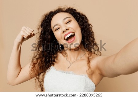 Close up happy young woman bride wear white wedding dress posing do selfie shot pov mobile cell phone show muscles isolated on plain beige background studio portrait Ceremony celebration party concept