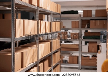 Goods packages lying on storehouse racks, waiting for transportration in empty storage. Products cardboard boxes on high shelves in shop distribution department warehouse Royalty-Free Stock Photo #2288095563