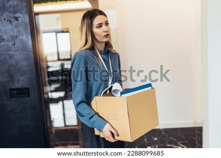Business woman carrying packing up all his personal belongings and files into a brown cardboard box to resignation in modern office, resign concept. Royalty-Free Stock Photo #2288099685