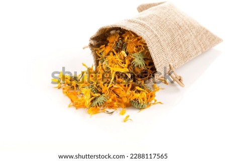 Calendula flowewr tea for infusion in sack on white background