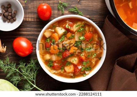 Vegetable cabbage soup in bowl over wooden background. Top view, flat lay
 Royalty-Free Stock Photo #2288124111
