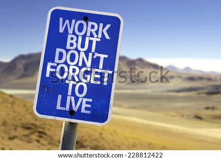 Work But Don't Forget to Live sign with a desert background Royalty-Free Stock Photo #228812422