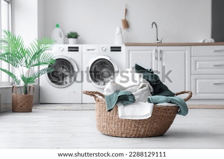 Basket with dirty clothes in laundry room Royalty-Free Stock Photo #2288129111