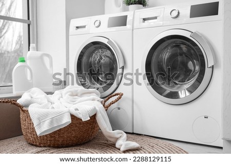 Basket with dirty clothes near washing machines in laundry room Royalty-Free Stock Photo #2288129115