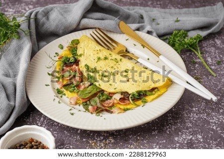 Tasty omelet with ham and greens on grey grunge background Royalty-Free Stock Photo #2288129963