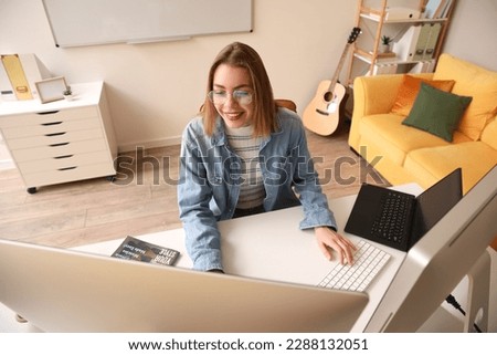 Female programmer working with computer at table in office