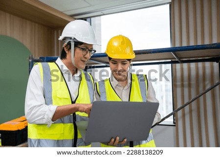 Asian young businessman and businesswoman working in construction site. Attractive professional engineer and and female building worker planning and discuss project as teamwork in corporate workplace.
