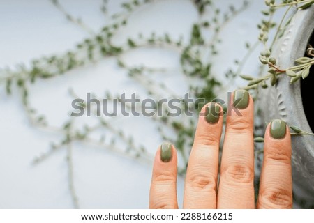 Women's hands with the colorful pattern on the nails. Spring vibes