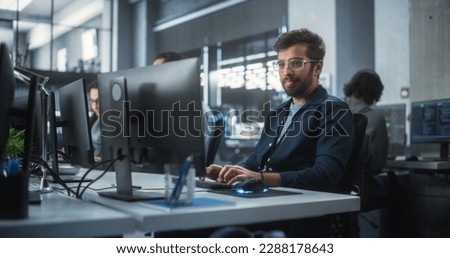 Portrait of a Thoughtful Engineer Working on Desktop Computer in a Technological Office Environment. Research and Development Department Writing Software Code for an Advanced Neural Network Project Royalty-Free Stock Photo #2288178643