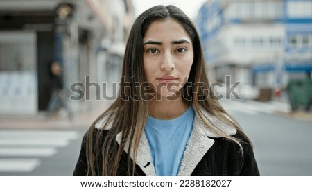 Young beautiful hispanic woman standing with serious expression at street Royalty-Free Stock Photo #2288182027