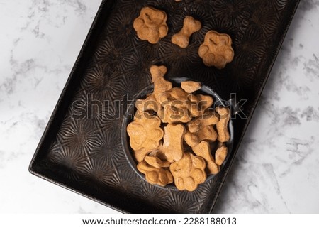 Heaping bowl of homemade baked dog treats on a marbled background. Royalty-Free Stock Photo #2288188013