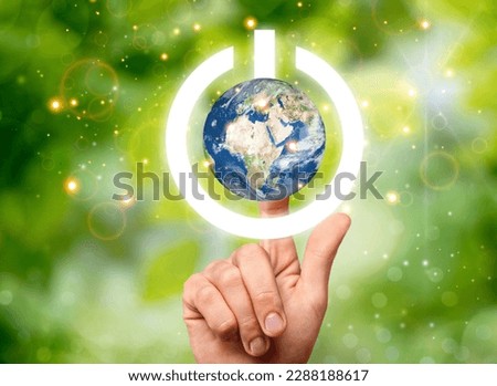 Globe of Earth with image of power button in hand