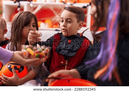 Group of kids wearing halloween costume receiving candies at home