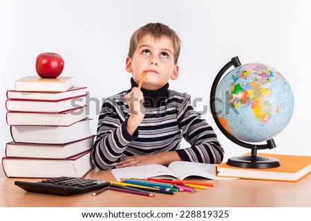 Cute schoolboy is thinking isolated on a white background