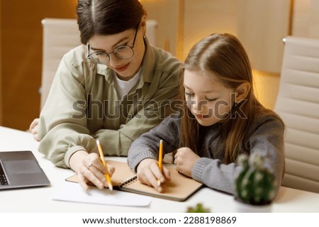 A young woman teacher conducts a private lesson with a little girl, a child psychologist. Royalty-Free Stock Photo #2288198869
