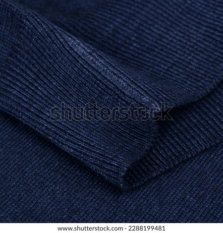 Knitted elastic band on navy blue wool jumper background close up