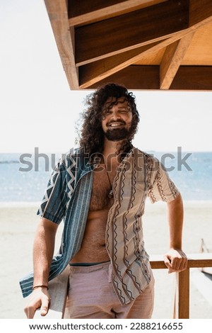 Portrait of carefree curly man relaxing on the beach during summer suny day