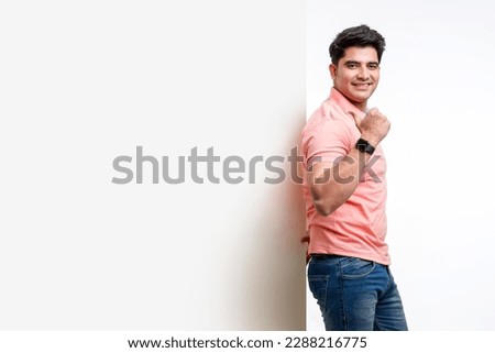 Young indian man showing and pointing of big white board with copy space Royalty-Free Stock Photo #2288216775