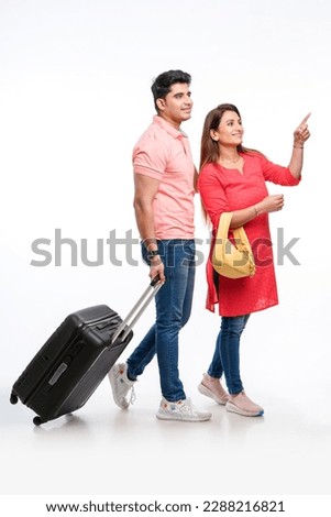 Indian couple holding trolly or suitcase bag in hand. Travel concept Royalty-Free Stock Photo #2288216821