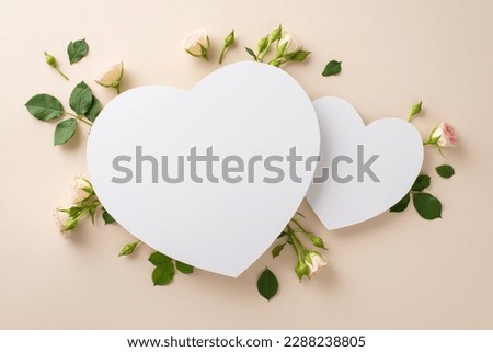 An alluring photograph from above displaying gorgeous miniature roses on a calming beige background, with a blank two hearts perfectly positioned for promotional content