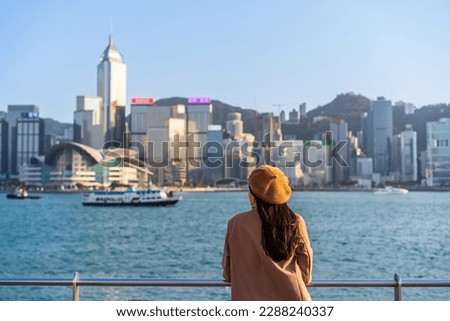 Young woman traveler relaxing and enjoying the sunset atmosphere at Victoria harbour in Hong Kong Royalty-Free Stock Photo #2288240337
