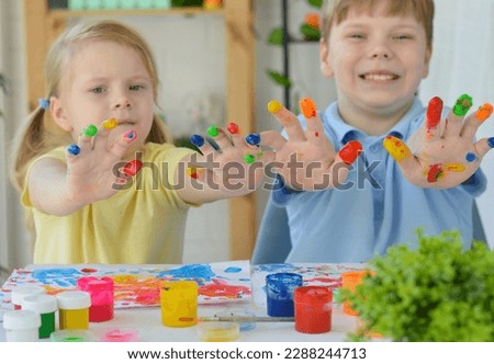 Children paint fingers drawing baby painting hand therapy children art play. Kids have fun and create picture. Palms of different colors. Sensory development and experiences