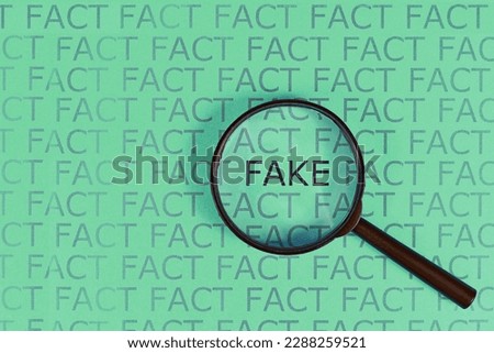 Fake News concept with words 'fact' in row and single word  'fake' highlighted by magnifying glass on green background Royalty-Free Stock Photo #2288259521