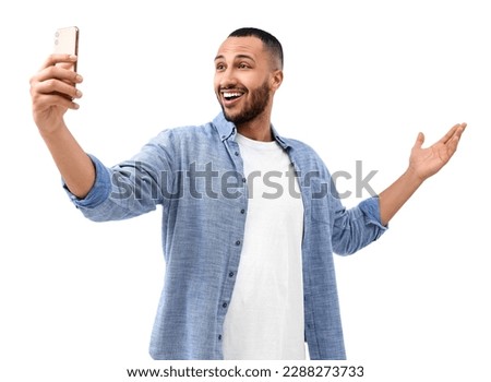 Smiling young man taking selfie with smartphone on white background Royalty-Free Stock Photo #2288273733