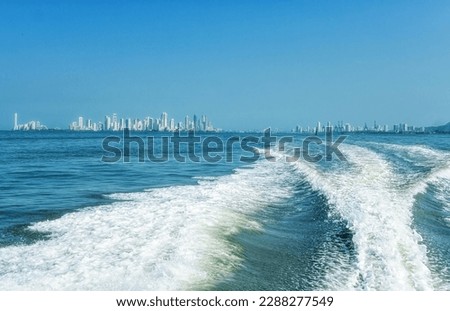 Skyscrapers in Cartagena City seen from the Caribban Sea with water splashing from a boat.