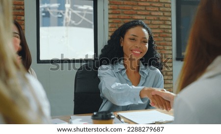 Young beautiful woman sign contract with business team. She having come to an agreement on the conditions of the business plan or project and feeling excited about the possibilities ahead.