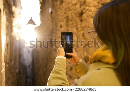 Portraits of a tourist taking photos with her mobile.
